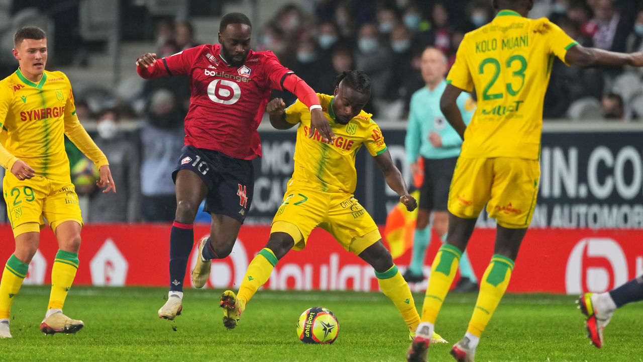 LILLE, FRANCE - NOVEMBER 27: Jonathan Ikone of Lille OSC competes for the ball with Moses Simon of FC Nantes during the Ligue 1 Uber Eats match between Lille OSC and FC Nantes at Stade Pierre Mauroy on November 27, 2021 in Lille, France.