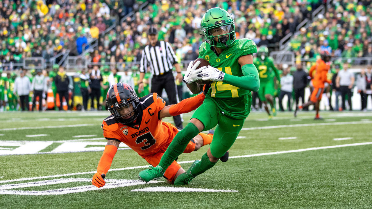 EUGENE, OR - NOVEMBER 27: Kris Hutson #14 of the Oregon Ducks catches a pass against Jaydon Grant #3 of the Oregon State Beavers at Autzen Stadium on November 27, 2021 in Eugene, Oregon.