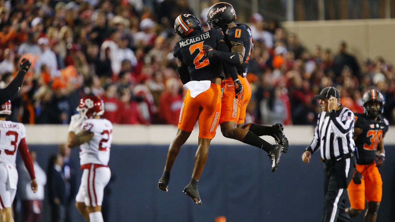 STILLWATER, OK - NOVEMBER 27: Safety Tanner McCalister #2 and cornerback Christian Holmes #0 of the Oklahoma State Cowboys celebrate after stopping a drive by the Oklahoma Sooners in the first quarter at Boone Pickens Stadium on November 27, 2021 in Stillwater, Oklahoma.