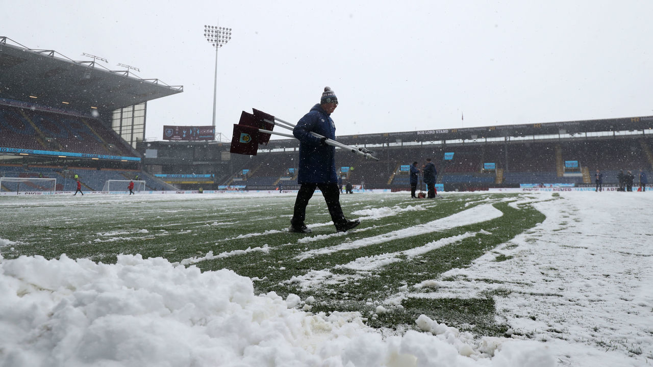 Snow is cleared from the pitch as the match is abandoned before the Premier League match at Turf Moor, Burnley. Picture date: Sunday November 28, 2021.