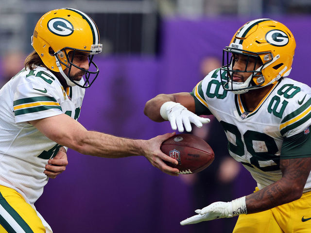 MINNEAPOLIS, MINNESOTA - NOVEMBER 21: Aaron Rodgers #12 of the Green Bay Packers hands the balls off to A.J. Dillon #28 during the game against the Minnesota Vikings in the second half at U.S. Bank Stadium on November 21, 2021 in Minneapolis, Minnesota.
