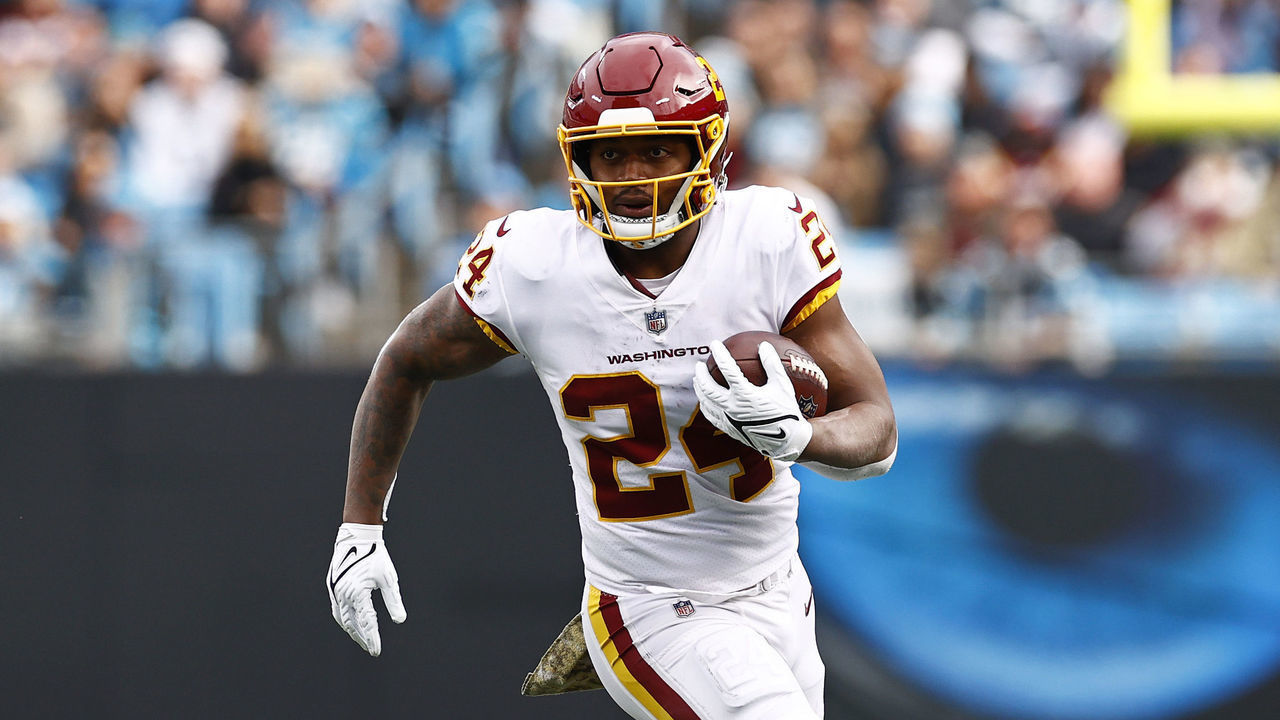 CHARLOTTE, NORTH CAROLINA - NOVEMBER 21: Antonio Gibson #24 of the Washington Football Team carries the ball against the defense of the Carolina Panthers during the second half of their game at Bank of America Stadium on November 21, 2021 in Charlotte, North Carolina.