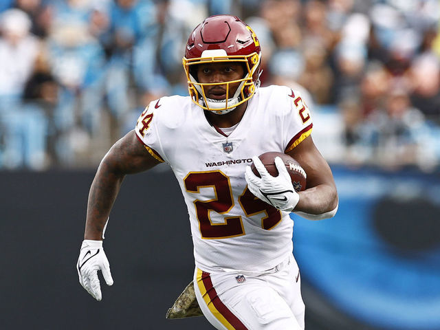 CHARLOTTE, NORTH CAROLINA - NOVEMBER 21: Antonio Gibson #24 of the Washington Football Team carries the ball against the defense of the Carolina Panthers during the second half of their game at Bank of America Stadium on November 21, 2021 in Charlotte, North Carolina.