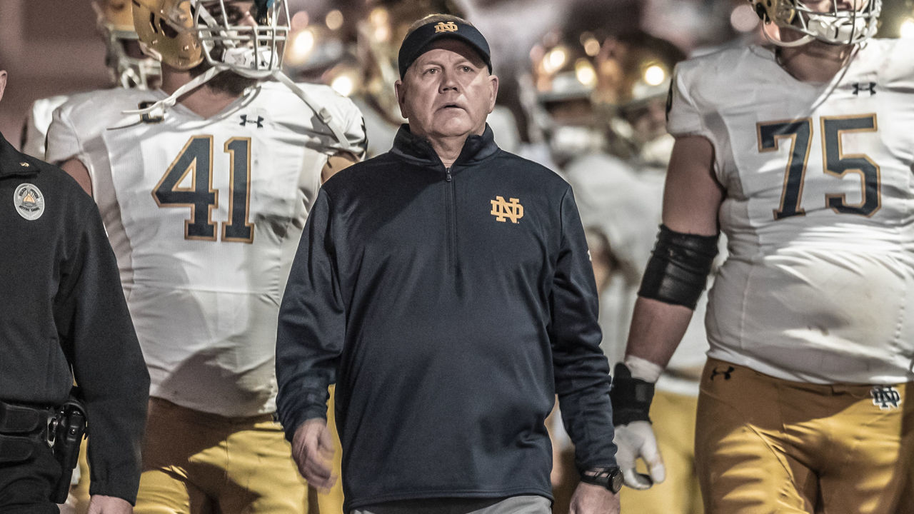 PALO ALTO, CA - NOVEMBER 27: Head Coach Brian Kelly of the Notre Dame Fighting Irish football team leads his team into the stadium before the second half of an NCAA football game against the Stanford Cardinal on November 27, 2021 at Stanford Stadium in Palo Alto, California; at right is Josh Lugg #75.