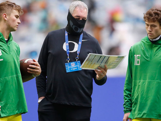 GLENDALE, ARIZONA - JANUARY 02: Offensive coordinator Joe Moorhead of the Oregon Ducks talks with quarterbacks Tyler Shough #12 and Bradley Yaffe #16 before the PlayStation Fiesta Bowl against the Iowa State Cyclones at State Farm Stadium on January 02, 2021 in Glendale, Arizona.