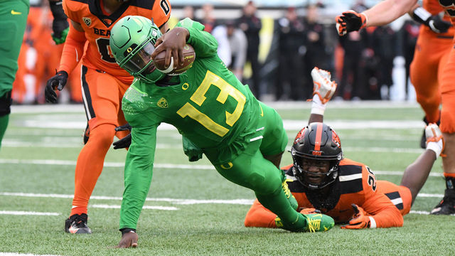 EUGENE, OR - NOVEMBER 27: Oregon Ducks QB Anthony Brown (13) leaps for the end zone for a 10-yard touchdown against Oregon State Beavers DB Akili Arnold (0) during a PAC-12 conference football game between the Oregon State Beavers and Oregon Ducks on November 27, 2021 at Autzen Stadium in Eugene, Oregon.