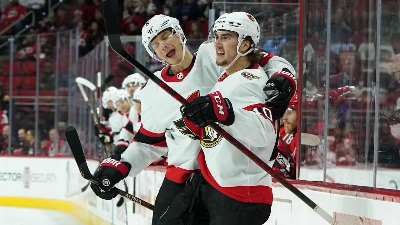 RALEIGH, NC - DECEMBER 2: Alex Formenton #10 of the Ottawa Senators scores a goal and celebrates with teammate Nick Holden #5 during the first period of an NHL game against the Carolina Hurricanes on December 2, 2021 at PNC Arena in Raleigh, North Carolina.