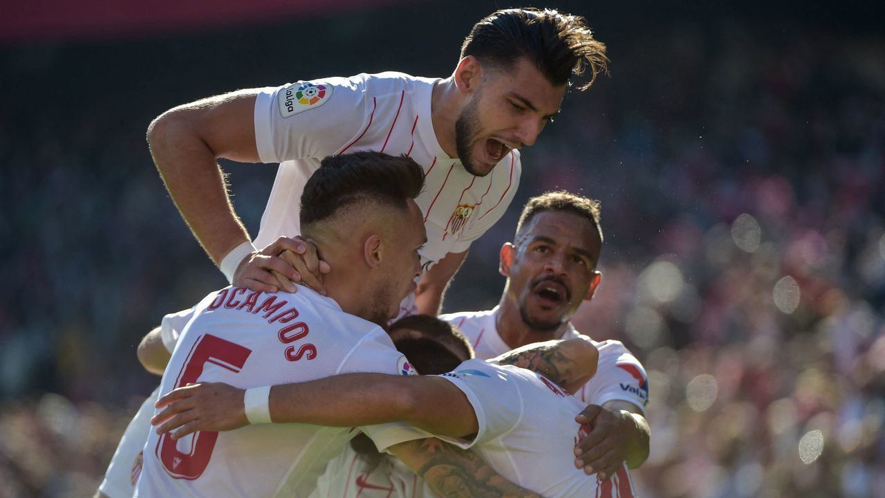 Sevilla's Argentinian midfielder Lucas Ocampos (L) celebrates with teammates after scoring his team's first goal during the Spanish League football match between Sevilla FC and Villarreal CF at the Ramon Sanchez Pizjuan stadium in Seville on December 4, 2021.