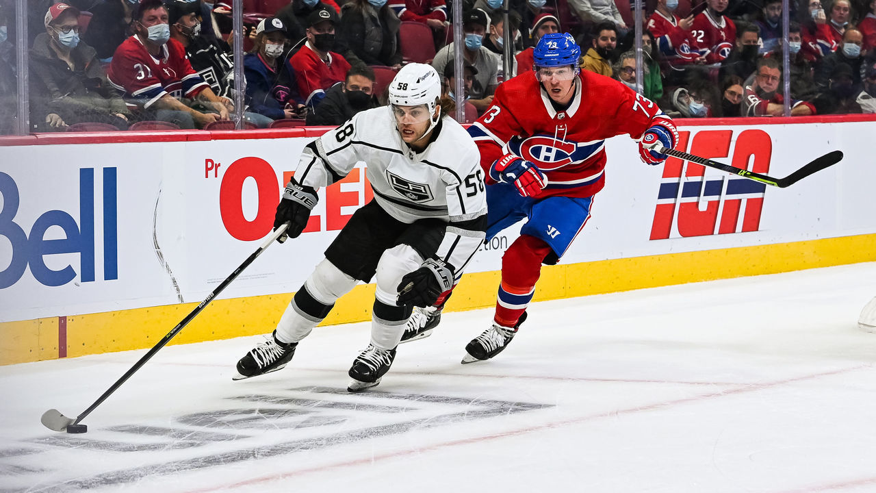 MONTREAL, QC - NOVEMBER 09: Los Angeles Kings defenceman Kale Clague (58) plays the puck while chased by Montreal Canadiens right wing Tyler Toffoli (73) during the Los Angeles Kings versus the Montreal Canadiens game on November 09, 2021, at Bell Centre in Montreal, QC