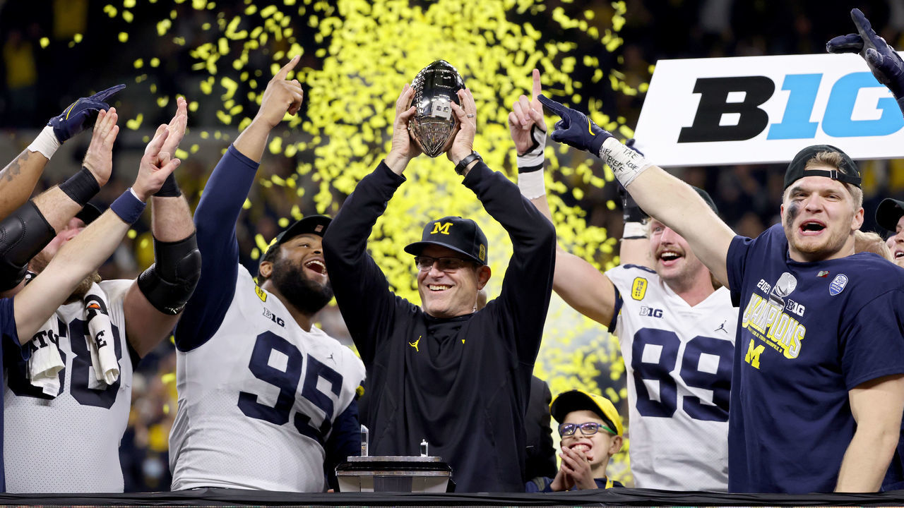 INDIANAPOLIS, INDIANA - DECEMBER 04: Head coach Jim Harbaugh of the Michigan Wolverines celebrates with the trophy after the Michigan Wolverines defeated the Iowa Hawkeyes 42-3 to win the Big Ten Championship game at Lucas Oil Stadium on December 04, 2021 in Indianapolis, Indiana.