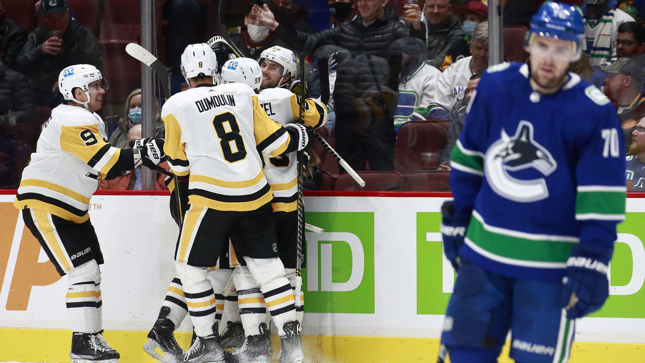 VANCOUVER, BC - DECEMBER 4: Tanner Pearson #70 of the Vancouver Canucks looks on dejected as Sidney Crosby #87 of the Pittsburgh Penguins celebrates with teammates after scoring during their NHL game against the Vancouver Canucks at Rogers Arena December 4, 2021 in Vancouver, British Columbia, Canada.
