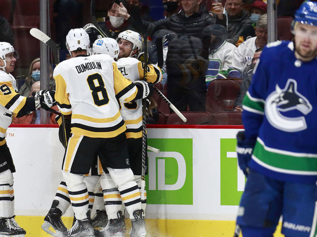 VANCOUVER, BC - DECEMBER 4: Tanner Pearson #70 of the Vancouver Canucks looks on dejected as Sidney Crosby #87 of the Pittsburgh Penguins celebrates with teammates after scoring during their NHL game against the Vancouver Canucks at Rogers Arena December 4, 2021 in Vancouver, British Columbia, Canada.