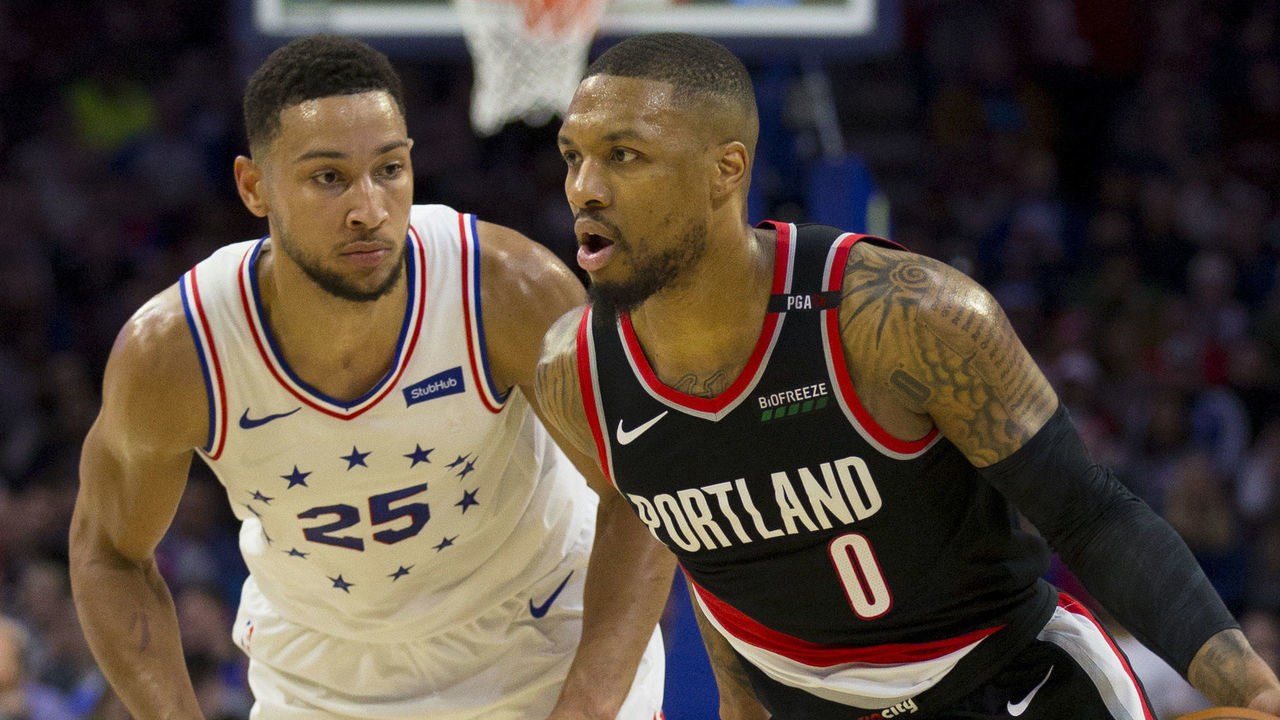 PHILADELPHIA, PA - FEBRUARY 23: Damian Lillard #0 of the Portland Trail Blazers dribbles the ball against Ben Simmons #25 of the Philadelphia 76ers at the Wells Fargo Center on February 23, 2019 in Philadelphia, Pennsylvania.
