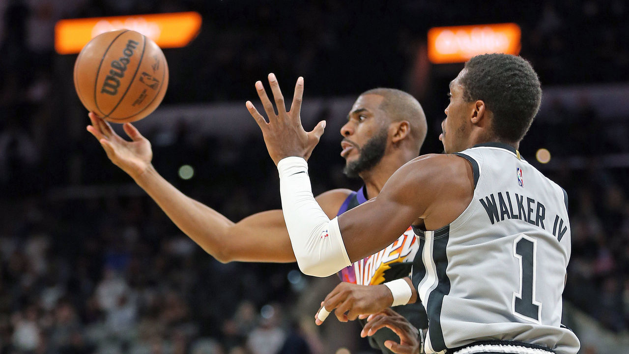 SAN ANTONIO, TX - NOVEMBER 22: Chris Paul #3 of the Phoenix Suns grabs a loose ball as Lonnie Walker #1 of the San Antonio Spurs watches in the second half at AT&T Center on November 22, 2021 in San Antonio, Texas. NOTE TO USER: User expressly acknowledges and agrees that , by downloading and or using this photograph, User is consenting to the terms and conditions of the Getty Images License Agreement.