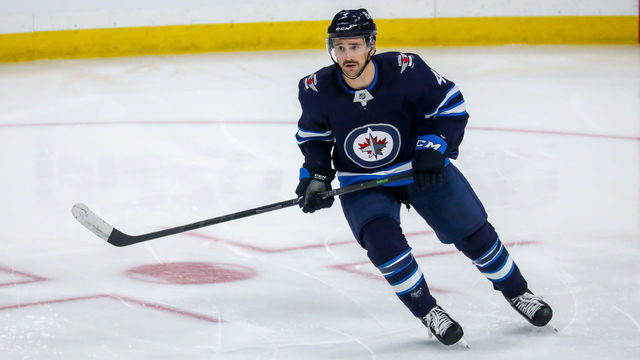 WINNIPEG, MB - NOVEMBER 22: Neal Pionk #4 of the Winnipeg Jets keeps an eye on the play during third period action against the Pittsburgh Penguins at Canada Life Centre on November 22, 2021 in Winnipeg, Manitoba, Canada.