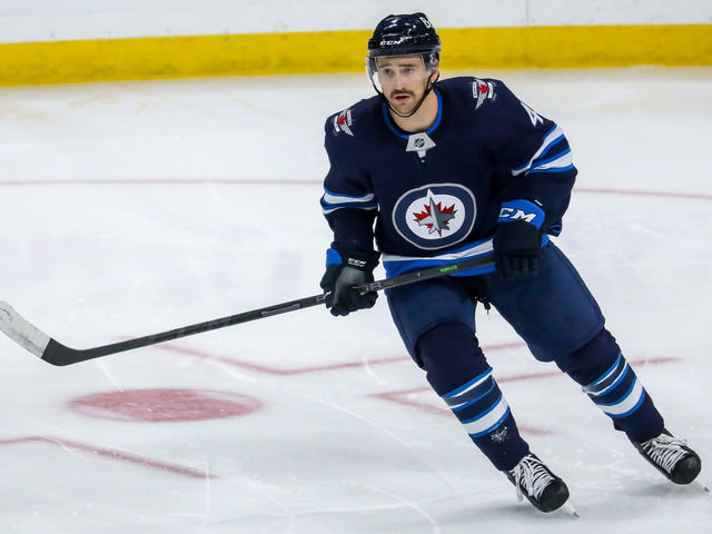 WINNIPEG, MB - NOVEMBER 22: Neal Pionk #4 of the Winnipeg Jets keeps an eye on the play during third period action against the Pittsburgh Penguins at Canada Life Centre on November 22, 2021 in Winnipeg, Manitoba, Canada.