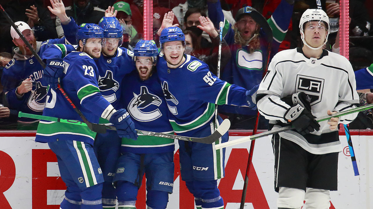 VANCOUVER, BC - DECEMBER 6: Tobias Bjornfot #7 of the Los Angeles Kings looks on dejected as Conor Garland #8 of the Vancouver Canucks is congratulated by teammates after scoring during their NHL game at Rogers Arena December 6, 2021 in Vancouver, British Columbia, Canada.