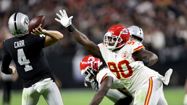 LAS VEGAS, NEVADA - NOVEMBER 14: Jarran Reed #90 of the Kansas City Chiefs rushes Derek Carr #4 of the Las Vegas Raiders during the first half of a game at Allegiant Stadium on November 14, 2021 in Las Vegas, Nevada.