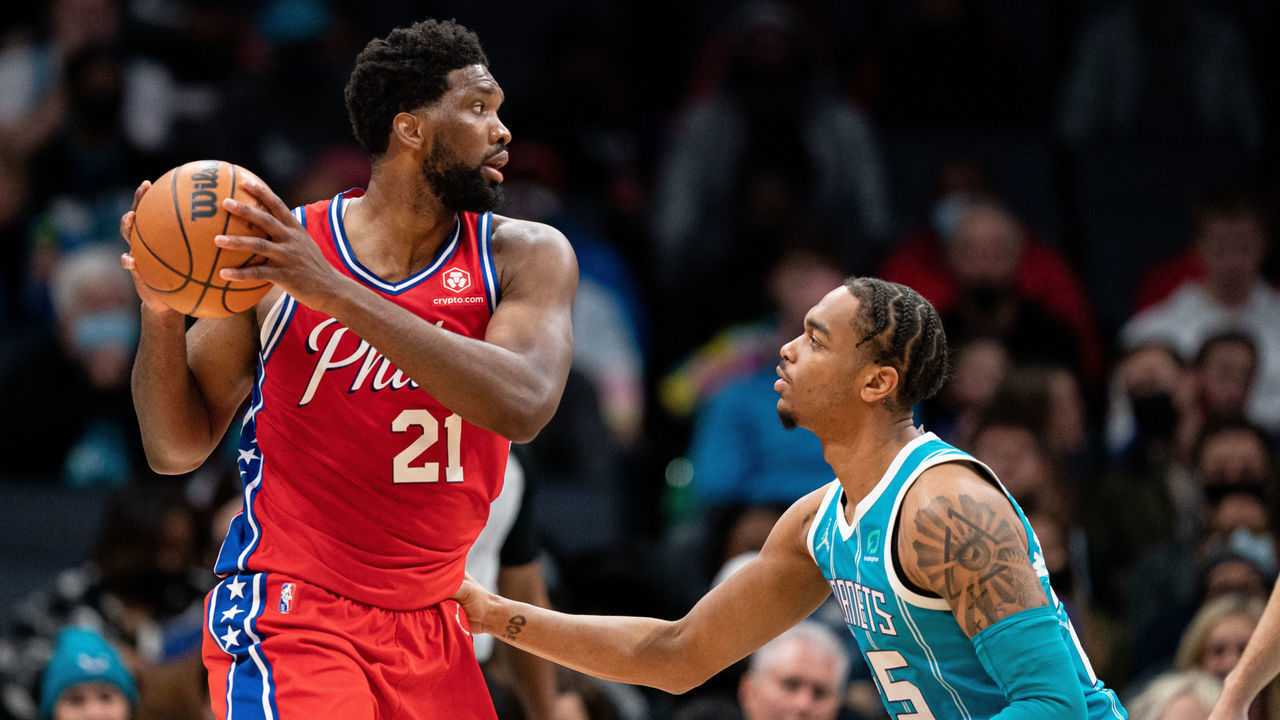 CHARLOTTE, NORTH CAROLINA - DECEMBER 08: P.J. Washington #25 of the Charlotte Hornets guards Joel Embiid #21 of the Philadelphia 76ers in the first quarter during their game at Spectrum Center on December 08, 2021 in Charlotte, North Carolina.