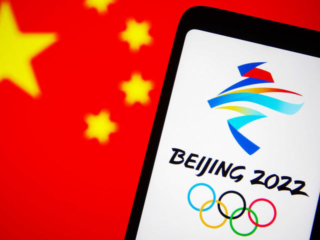 UKRAINE - 2021/12/07: In this photo illustration, the 2022 Winter Olympics (XXIV Olympic Winter Games or Beijing 2022) logo is seen on a smartphone screen with a flag of China in the background. (Photo Illustration by Pavlo Gonchar/SOPA Images/LightRocket via Getty Images)