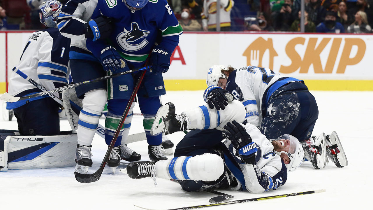 VANCOUVER, BC - DECEMBER 10: Conor Garland #8 of the Vancouver Canucks checks Blake Wheeler #26 of the Winnipeg Jets during their NHL game at Rogers Arena December 10, 2021 in Vancouver, British Columbia, Canada.