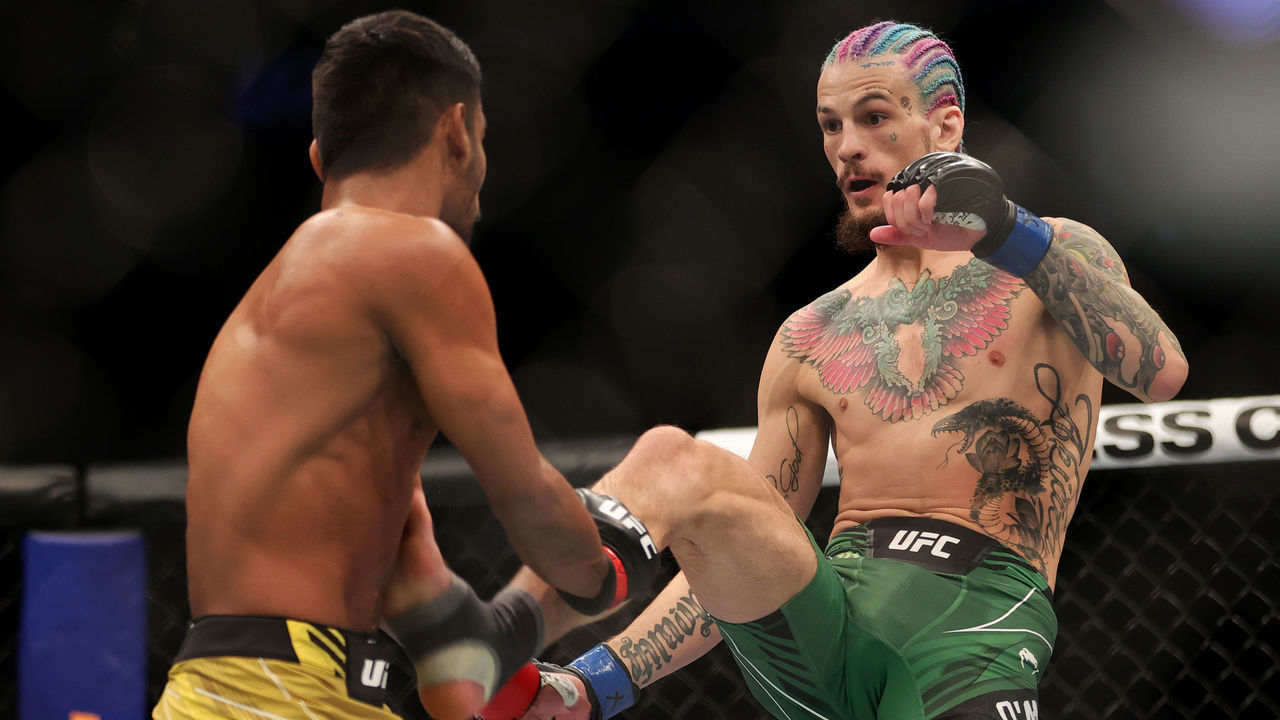 LAS VEGAS, NEVADA - DECEMBER 11: Sean O'Malley (R) kicks Raulian Paiva of Brazil in their bantamweight fight during the UFC 269 event at T-Mobile Arena on December 11, 2021 in Las Vegas, Nevada.