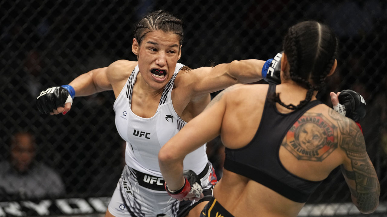 LAS VEGAS, NEVADA - DECEMBER 11: (L-R) Julianna Pena punches Amanda Nunes of Brazil in their UFC bantamweight championship bout during the UFC 269 on December 11, 2021 in Las Vegas, Nevada.