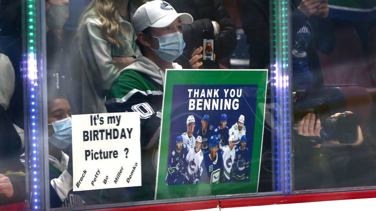 VANCOUVER, BC - DECEMBER 06: A fan holds up a thank you Benning sign in reference to the firing of Canucks former GM Jim Benning the day before the Vancouver Canucks play the LA Kings during their NHL game at Rogers Arena on December 6, 2021 in Vancouver, British Columbia, Canada.