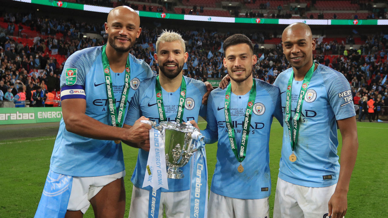 LONDON, ENGLAND - FEBRUARY 24: Vincent Kompany, Sergio Aguero, David Silva and Fernandinho of Manchester City celebrate victory with the trophy after the Carabao Cup Final between Chelsea and Manchester City at Wembley Stadium on February 24, 2019 in London, England.