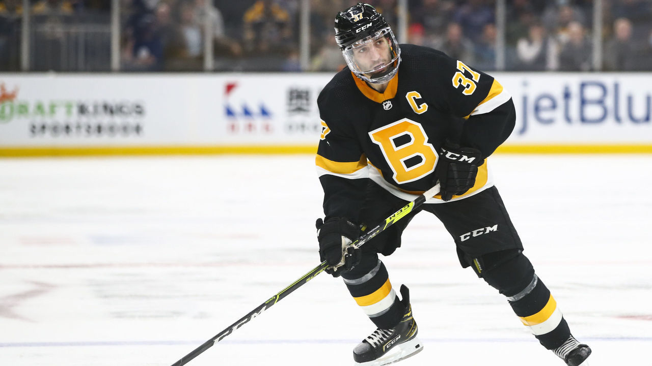 BOSTON, MA - DECEMBER 14: Patrice Bergeron #37 of the Boston Bruins skates with the puck in the third period of a game against the Vegas Golden Knights at TD Garden on December 14, 2021 in Boston, Massachusetts.