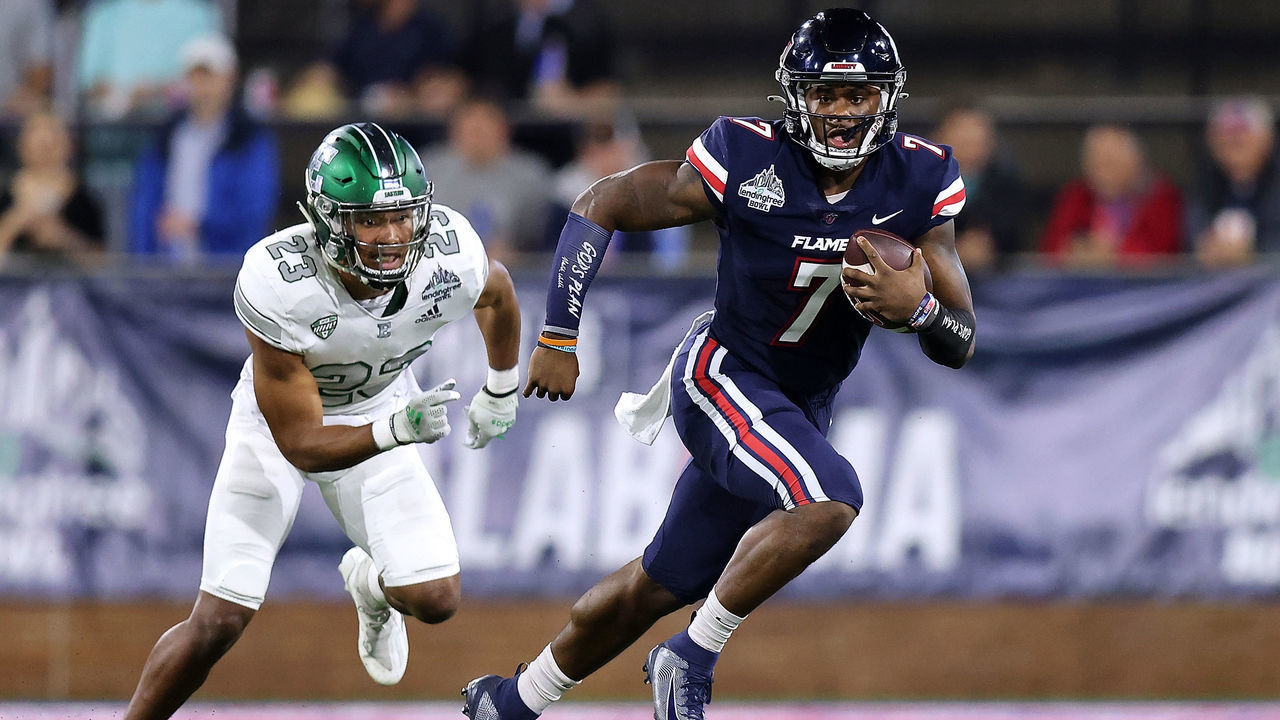 MOBILE, ALABAMA - DECEMBER 18: Malik Willis #7 of the Liberty Flames runs with the ball as Blake Bogan #23 of the Eastern Michigan Eagles defends during the first half of the LendingTree Bowl at Hancock Whitney Stadium on December 18, 2021 in Mobile, Alabama.
