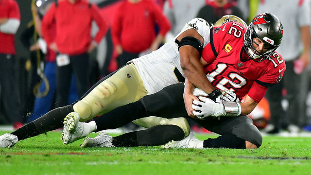 TAMPA, FLORIDA - DECEMBER 19: Tom Brady #12 of the Tampa Bay Buccaneers is sacked by Marcus Davenport #92 of the New Orleans Saints during the 2nd quarter of the game at Raymond James Stadium on December 19, 2021 in Tampa, Florida.