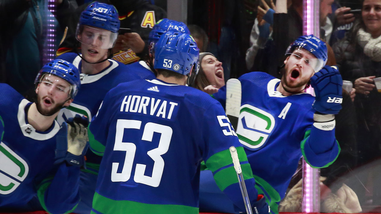 VANCOUVER, BC - DECEMBER 12: Bo Horvat #53 of the Vancouver Canucks is congratulated by teammates after scoring during their NHL game against the Columbus Blue Jackets at Rogers Arena December 12, 2021 in Vancouver, British Columbia, Canada. "n