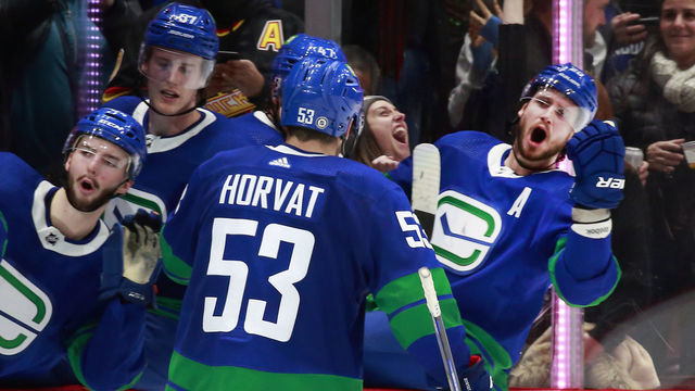 VANCOUVER, BC - DECEMBER 12: Bo Horvat #53 of the Vancouver Canucks is congratulated by teammates after scoring during their NHL game against the Columbus Blue Jackets at Rogers Arena December 12, 2021 in Vancouver, British Columbia, Canada. "n