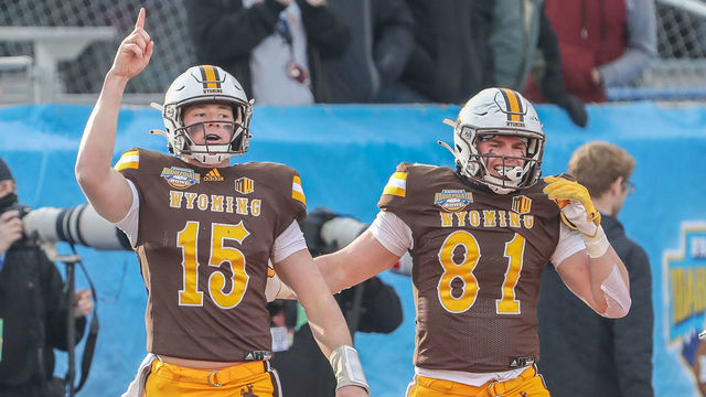 BOISE, ID - DECEMBER 21: Quarterback Levi Williams #15 and tight end Treyton Welch #81 of the Wyoming Cowboys celebrate a touchdown during first half action against the Kent State Golden Flashes at the Famous Idaho Potato Bowl on December 21, 2021 at Albertsons Stadium in Boise, Idaho.