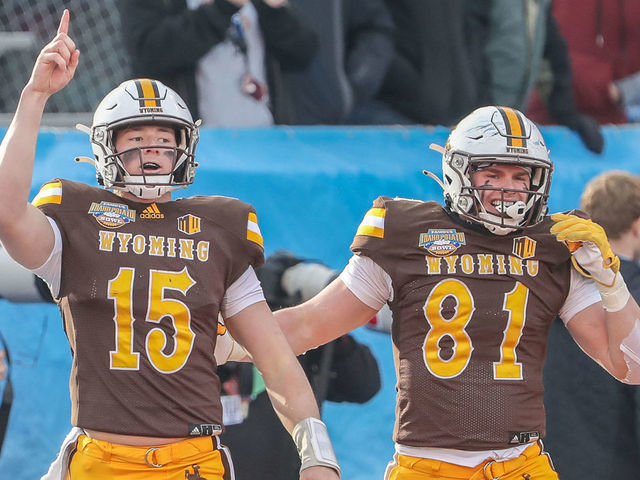 BOISE, ID - DECEMBER 21: Quarterback Levi Williams #15 and tight end Treyton Welch #81 of the Wyoming Cowboys celebrate a touchdown during first half action against the Kent State Golden Flashes at the Famous Idaho Potato Bowl on December 21, 2021 at Albertsons Stadium in Boise, Idaho.