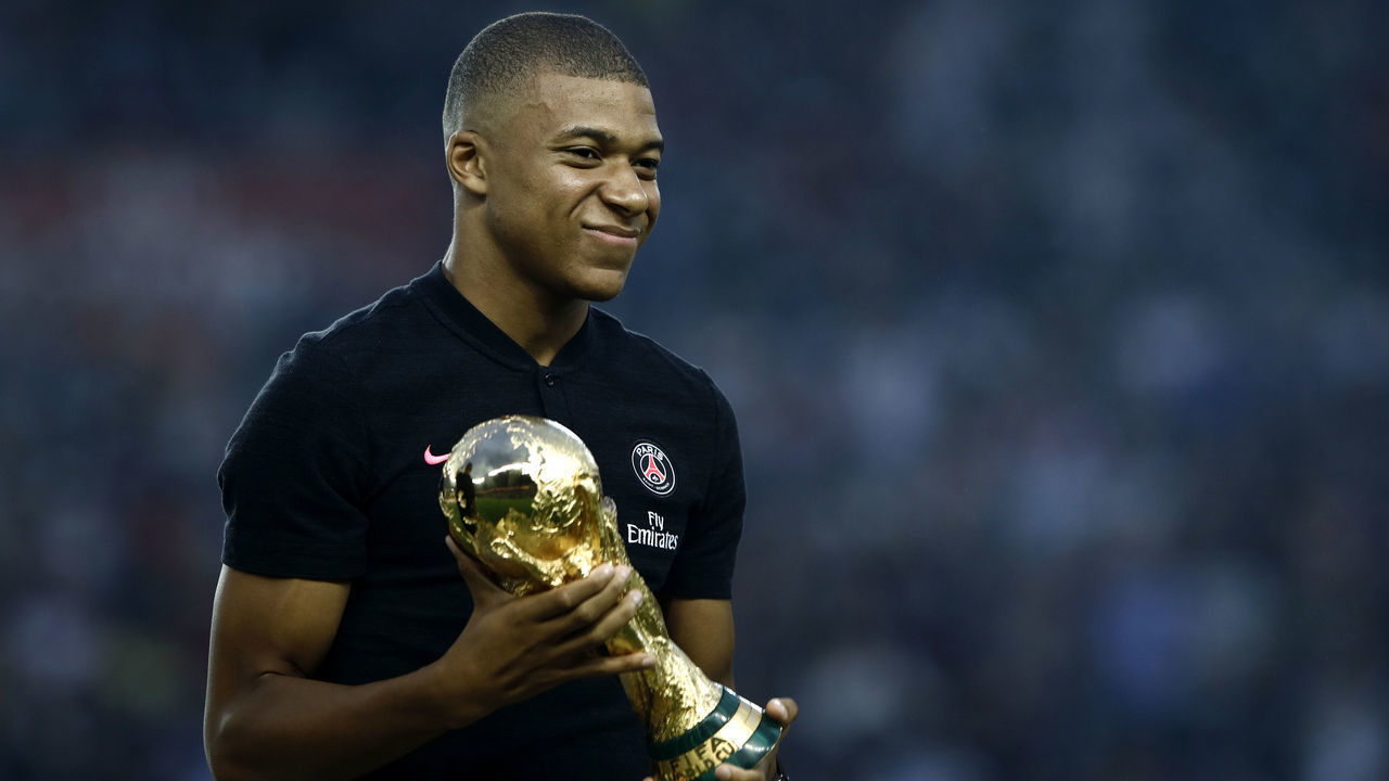 Paris Saint-Germain's French forward Kylian Mbappe poses and holds the 2018 World Cup Trophy prior to the French L1 football match between Paris Saint-Germain and Caen on August 12, 2018 at the Parc des Princes, in Paris.