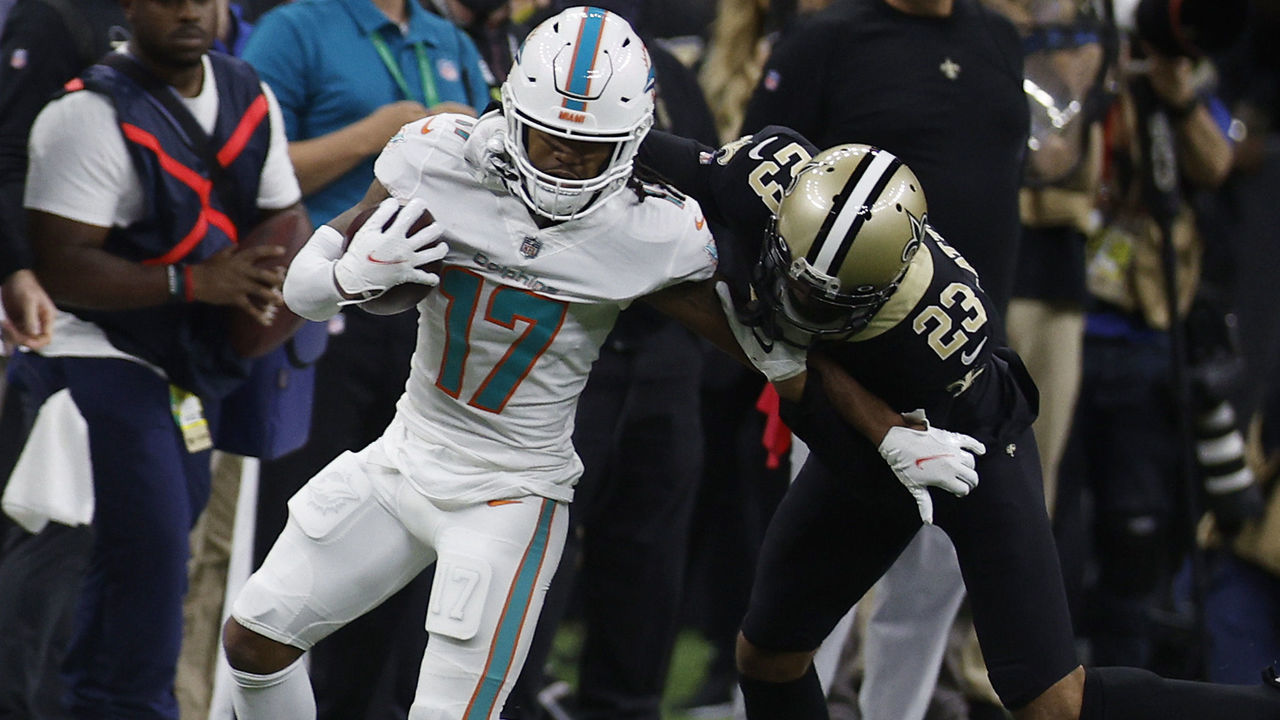 NEW ORLEANS, LOUISIANA - DECEMBER 27: Jaylen Waddle #17 of the Miami Dolphins carries the ball after a reception as Marshon Lattimore #23 of the New Orleans Saints defends during the first quarter at Caesars Superdome on December 27, 2021 in New Orleans, Louisiana.