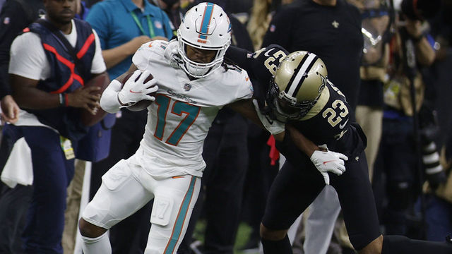 NEW ORLEANS, LOUISIANA - DECEMBER 27: Jaylen Waddle #17 of the Miami Dolphins carries the ball after a reception as Marshon Lattimore #23 of the New Orleans Saints defends during the first quarter at Caesars Superdome on December 27, 2021 in New Orleans, Louisiana.