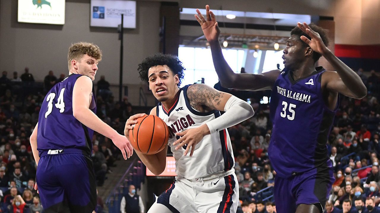 SPOKANE, WA - DECEMBER 28: Julian Strawther #0 of the Gonzaga Bulldogs drives against Pape Momar Cisse #35 of the North Alabama Lions during the first half at McCarthey Athletic Center on December 28, 2021 in Spokane, Washington.