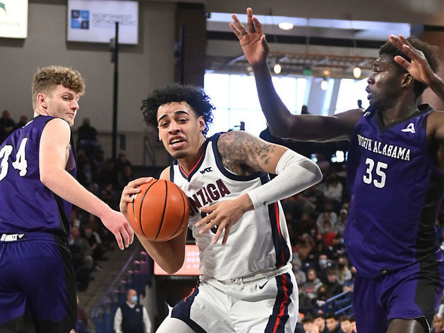 SPOKANE, WA - DECEMBER 28: Julian Strawther #0 of the Gonzaga Bulldogs drives against Pape Momar Cisse #35 of the North Alabama Lions during the first half at McCarthey Athletic Center on December 28, 2021 in Spokane, Washington.
