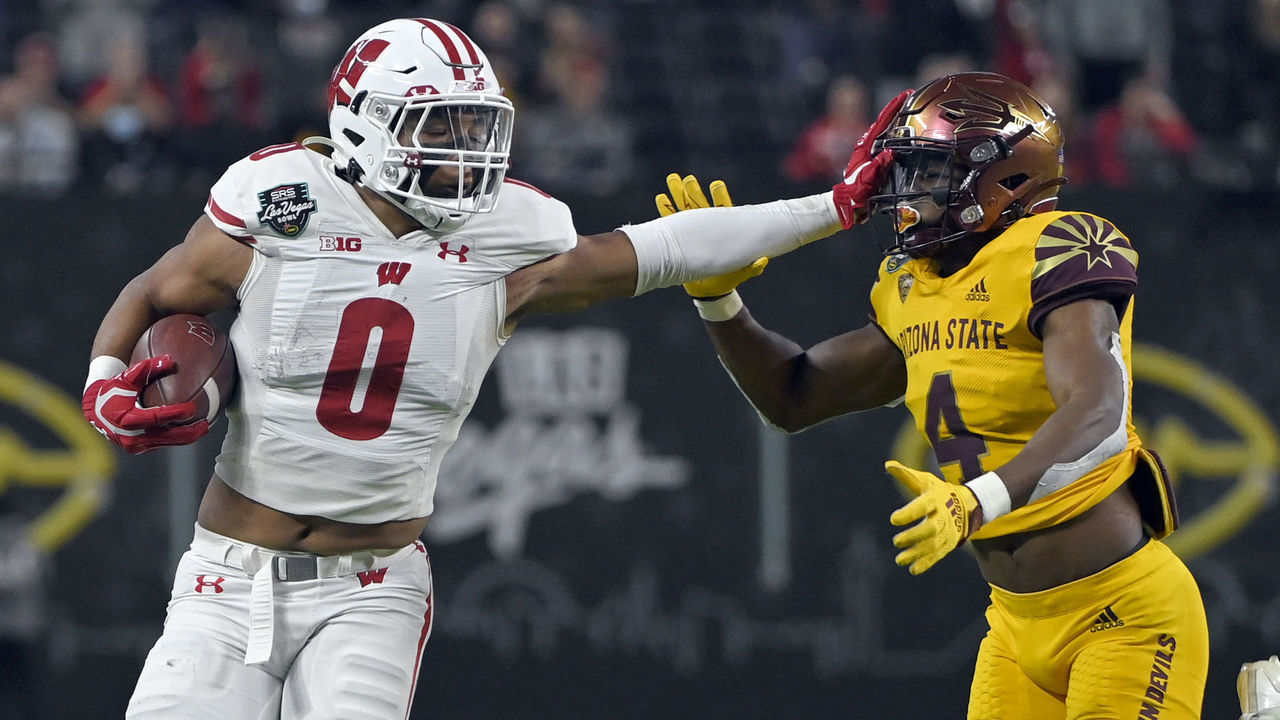 LAS VEGAS, NEVADA - DECEMBER 30: Running back Braelon Allen #0 of the Wisconsin Badgers stiff arms defensive back Evan Fields #4 of the Arizona State Sun Devils during the SRS Distribution Las Vegas Bowl at Allegiant Stadium on December 30, 2021 in Las Vegas, Nevada.