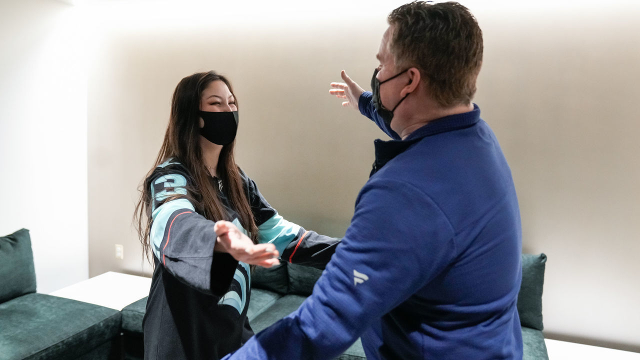 SEATTLE, WASHINGTON - JANUARY 01: Seattle Kraken fan Nadia Popovici and Vancouver Canucks equipment manager Brian Hamilton meet before the game at Climate Pledge Arena on January 01, 2022 in Seattle, Washington. Popovici made headlines by alerting Hamilton at a previous game between the teams on October 23rd of a cancerous mole.