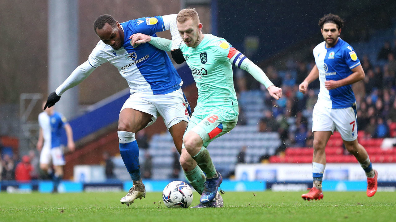 BLACKBURN, ENGLAND - JANUARY 02: Lewis O'Brien of Huddersfield Town is challenged by Ryan Nyambe of Blackburn Rovers during the Sky Bet Championship match between Blackburn Rovers and Huddersfield Town at Ewood Park on January 02, 2022 in Blackburn, England.