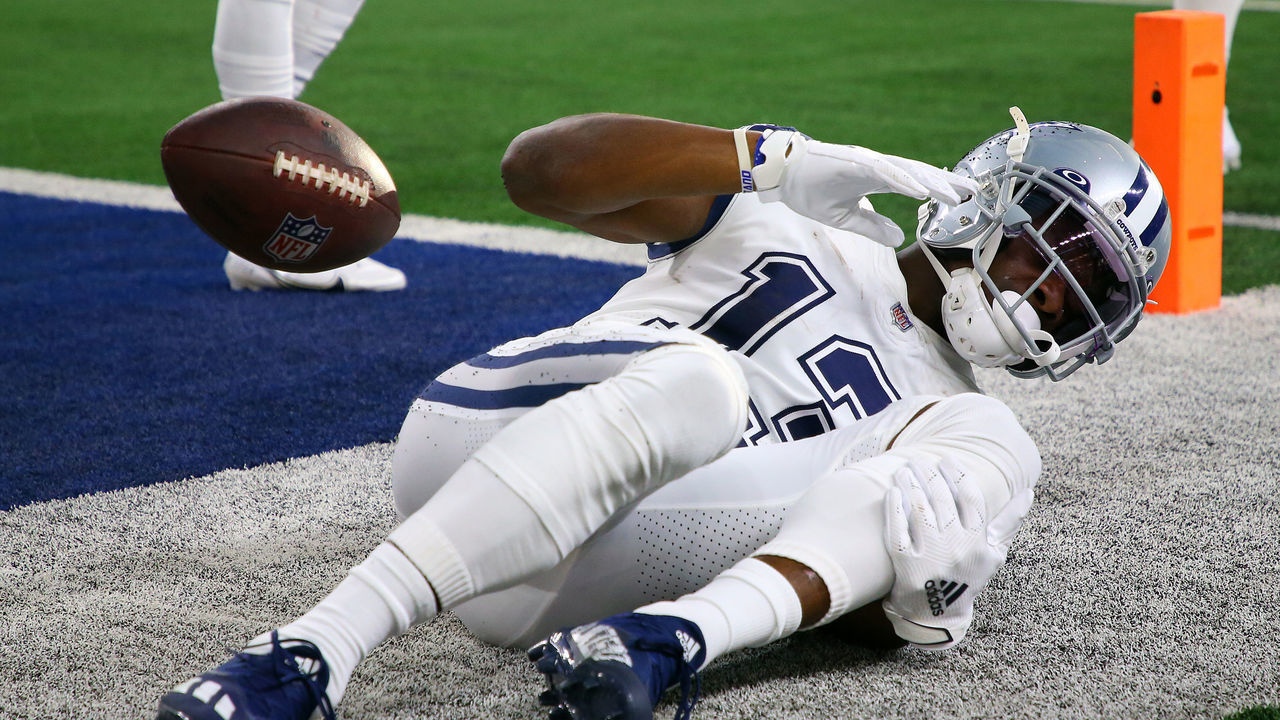 ARLINGTON, TEXAS - JANUARY 02: Michael Gallup #13 of the Dallas Cowboys holds his leg after catching the ball for a touchdown during the second quarter against the Arizona Cardinals at AT&T Stadium on January 02, 2022 in Arlington, Texas.