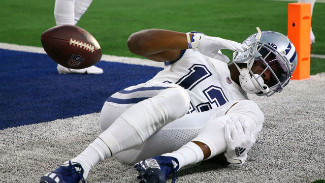 ARLINGTON, TEXAS - JANUARY 02: Michael Gallup #13 of the Dallas Cowboys holds his leg after catching the ball for a touchdown during the second quarter against the Arizona Cardinals at AT&T Stadium on January 02, 2022 in Arlington, Texas.
