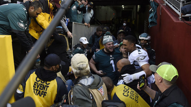 LANDOVER, MARYLAND - JANUARY 02: Jalen Hurts #1 of the Philadelphia Eagles celebrates with fans who fell onto the ground after a railing collapsed following the win over the Washington Football Team 20-16 at FedExField on January 02, 2022 in Landover, Maryland.