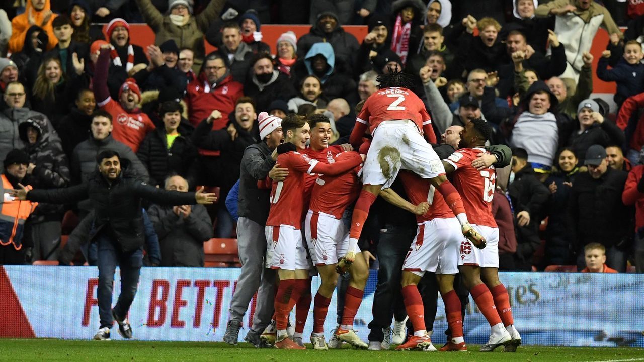 Nottingham Forest's English striker Lewis Grabban celebrates with teammates after scoring the opening goal during the English FA Cup third round football match between Nottingham Forest and Arsenal at The City Ground in Nottingham, central England, on January 9, 2022. - - RESTRICTED TO EDITORIAL USE. No use with unauthorized audio, video, data, fixture lists, club/league logos or 'live' services. Online in-match use limited to 120 images. An additional 40 images may be used in extra time. No video emulation. Social media in-match use limited to 120 images. An additional 40 images may be used in extra time. No use in betting publications, games or single club/league/player publications.