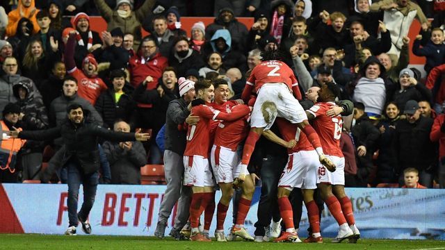 Nottingham Forest's English striker Lewis Grabban celebrates with teammates after scoring the opening goal during the English FA Cup third round football match between Nottingham Forest and Arsenal at The City Ground in Nottingham, central England, on January 9, 2022. - - RESTRICTED TO EDITORIAL USE. No use with unauthorized audio, video, data, fixture lists, club/league logos or 'live' services. Online in-match use limited to 120 images. An additional 40 images may be used in extra time. No video emulation. Social media in-match use limited to 120 images. An additional 40 images may be used in extra time. No use in betting publications, games or single club/league/player publications.