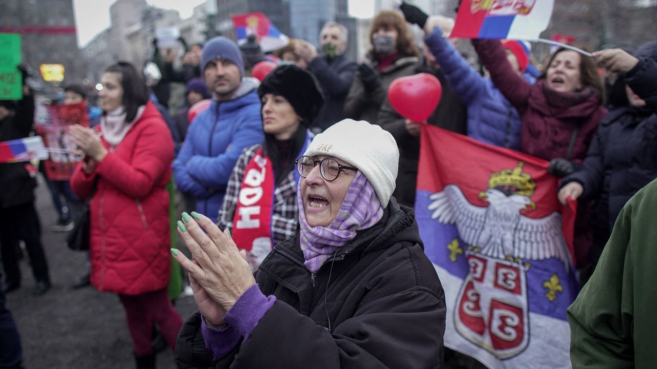 Supporters of Serbian's tennis player Novak Djokovic hold national flags during a rally in front of Serbia's National Assembly, in Belgrade, on January 9, 2022. - People protest against the Australia's government decision to revoke Serbian tennis player Novak Djokovic's visa, on his arrival in Melbourne.